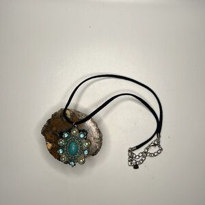Turquoise toned pendant on a leather strap